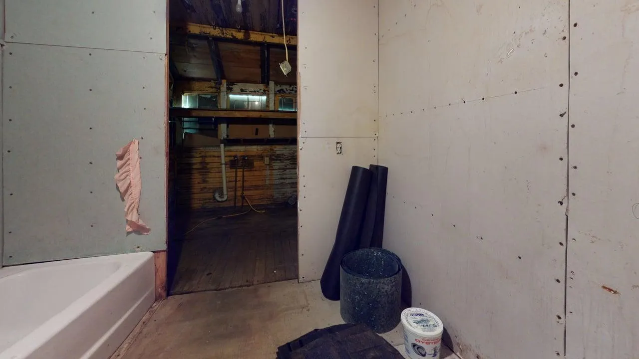 Bathroom before — deteriorated fixtures, contamination, structural damage