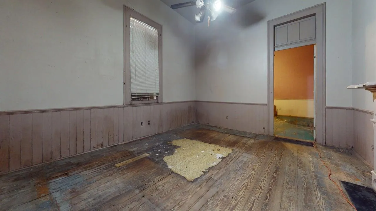 Bedroom before — fire damage, hoarding contamination, structural deterioration